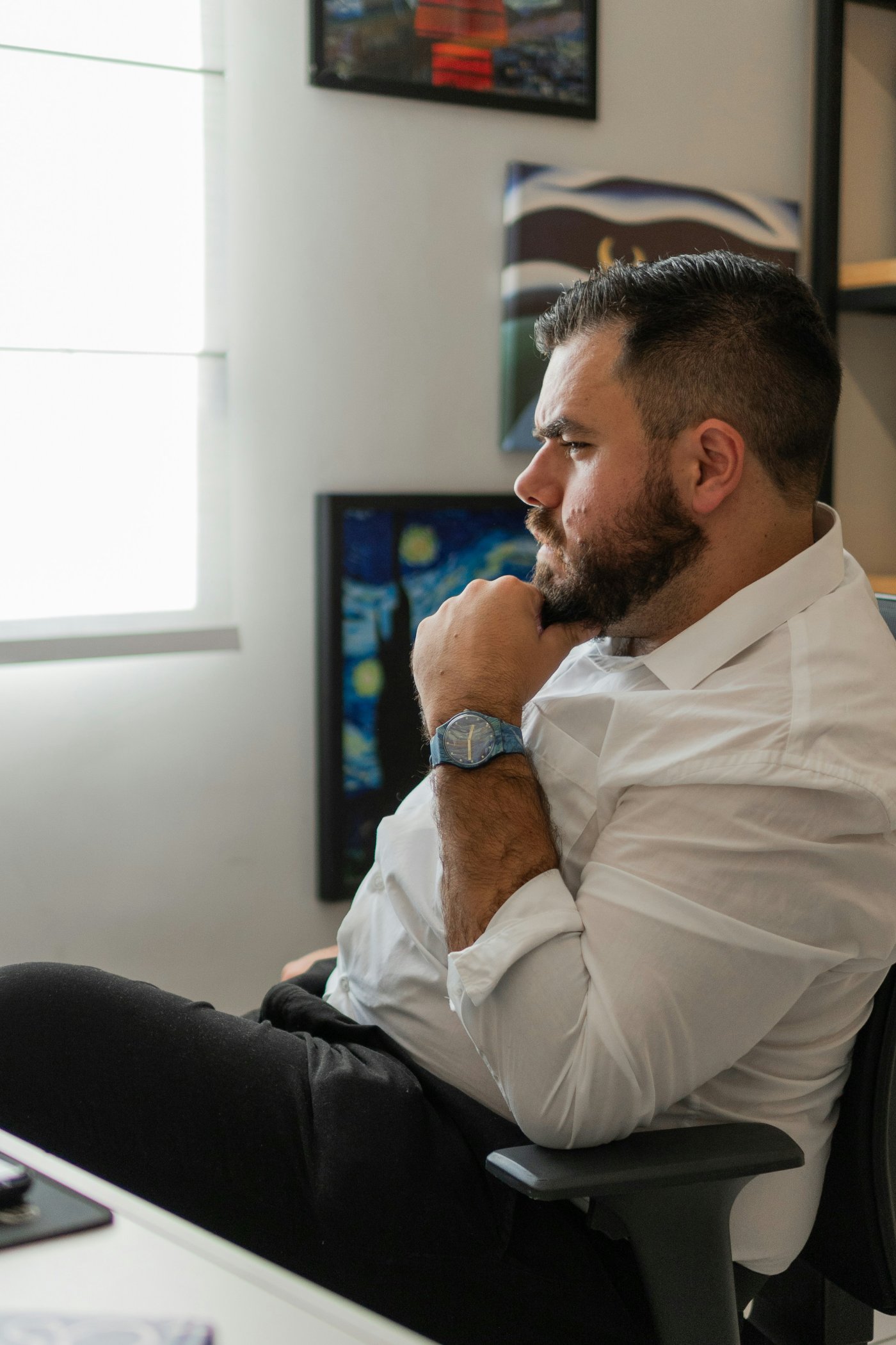 A product leader sitting back at his desk, thinking through a decision